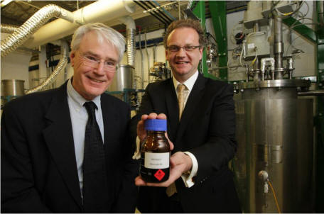 Scientists holding up a bottle